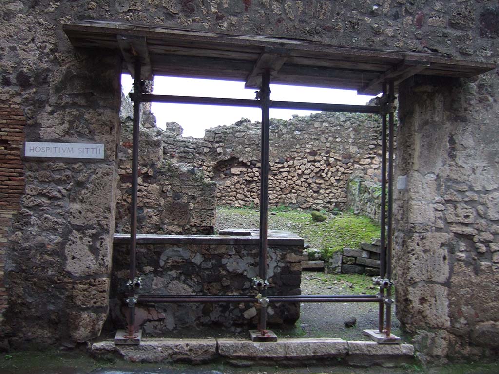 VII.1.44 Pompeii. December 2005. Looking east to entrance.
The hospitium had two doorways divided by a central pilaster, seen on the right above.
This pilaster was painted with the sign of an elephant surrounded around its body by a huge serpent and being rescued by a pigmy.
Above was a graffiti which possibly identified the owner as Sittius, who boasted that he had restored the elephant.
SITTIVS  RESTITVIT  ELEPHANTVM     [CIL IV 806]
Underneath was an advert
HOSPITIVM  HIC  LOCATVR
TRICLINIVM  CVM  TRIBVS LECTIS
ET  COMM(odis)     [CIL IV 807]
See Dobbins, J & Foss, P., 2008. The World of Pompeii. New York: Routledge. (p.477)

Mau thought 
Sittius restituit elephantu(m)  [CIL IV 806]   (Sittius restored the elephant) was referring to the repainting of the sign.
He thought the owner, whether Sittius or an unknown, was keen to rent the premises as under the elephant was the painted notice
Hospitium hic locatur - triclinium cum tribus lectis  [CIL IV 807]   (Inn to let  triclinium with 3 couches). 
Mau said the rest of the inscription was illegible.
See Mau, A., 1907, translated by Kelsey F. W. Pompeii: Its Life and Art. New York: Macmillan. (p.400)

