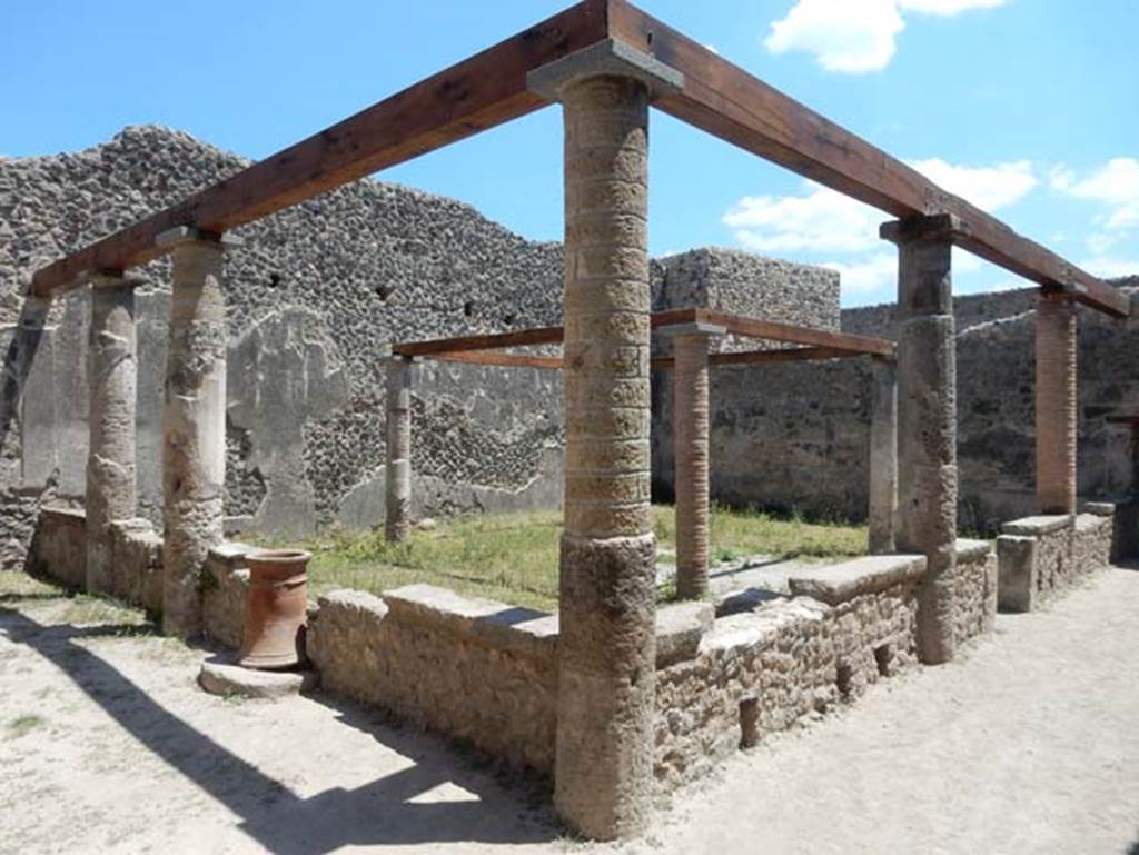 VII.1.47 Pompeii. May 2017. Looking south-east across peristyle 19. Photo courtesy of Buzz Ferebee.
According to Jashemski –
The peristyle garden at the rear of the tablinum of the house at entrance 47  was enclosed on the west and north by a portico supported by five columns which were joined by a low wall, with an entrance to the garden on the west.
Both the mouth of a cistern (on the north) and a terracotta puteal (on the west) were incorporated into the low wall.
The four small columns in the garden probably supported a pergola which shaded a wooden triclinium.
See Jashemski, W. F., 1993. The Gardens of Pompeii, Volume II: Appendices. New York: Caratzas. (p.169-71.

According to Soprano –
Ubicazione: giardino.
Bibliog. Fiorelli, op. c, p.180; idem Scavi di Pompei dal 1872, p.12;
Breton, op. c. p.317; Overbeck, op. c, p.286.
Al centro del giardino s’innalzavano quattro piccole colonne che probabilmente sostenevano il pergolato di letti tricliniare in legno.
See Soprano, P. (1950). I triclini all’aperto di Pompei. (In Pompeiana, raccolta di studi per il secondo centenario degli scavi di Pompei. Napoli, Gaetano Macchiaroli, Editore, P. 308, no.34).

