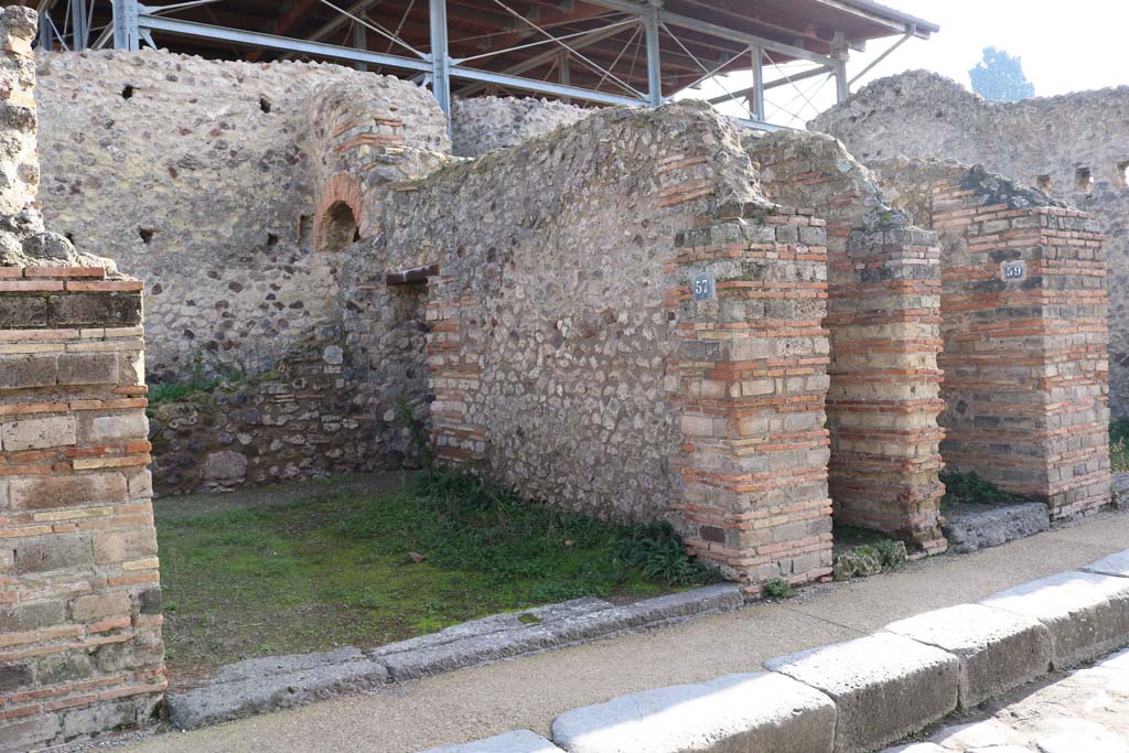 VII.1.57, Pompeii, on left. December 2018. 
Looking east on Vicolo del Lupanare towards entrance doorways. Photo courtesy of Aude Durand.
