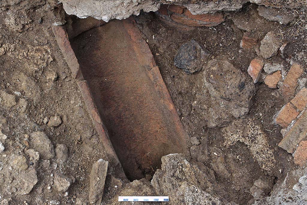 Fig. 37  Pompi, boulangerie VII 2, 22  Rigole de vidange du bassin construite avec des imbrices.
On distingue sur la droite la colonne constituant langle du bassin et son effondrement. En haut, la ligne de mortier visible constitue la base de la reconstruction moderne du bassin (vue de lest).
Clich : C. Salviani  EFR.
