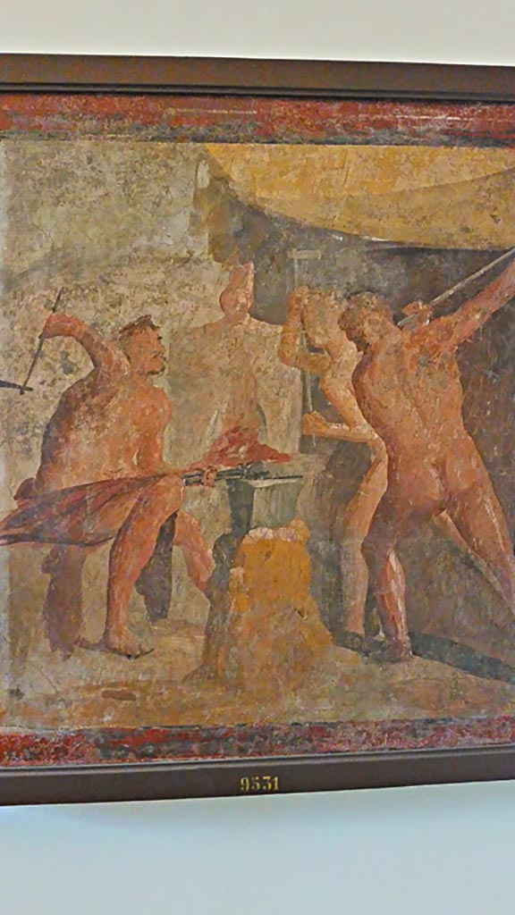 VII.2.25 Pompeii. Wall painting from triclinium.
The workshop of Hephaistos, where the powerfully muscled Cyclops forge the armour of the heroes.
Now in Naples Archaeological Museum. Inventory number 9531.
Photo courtesy of Giuseppe Ciaramella, November 2018.