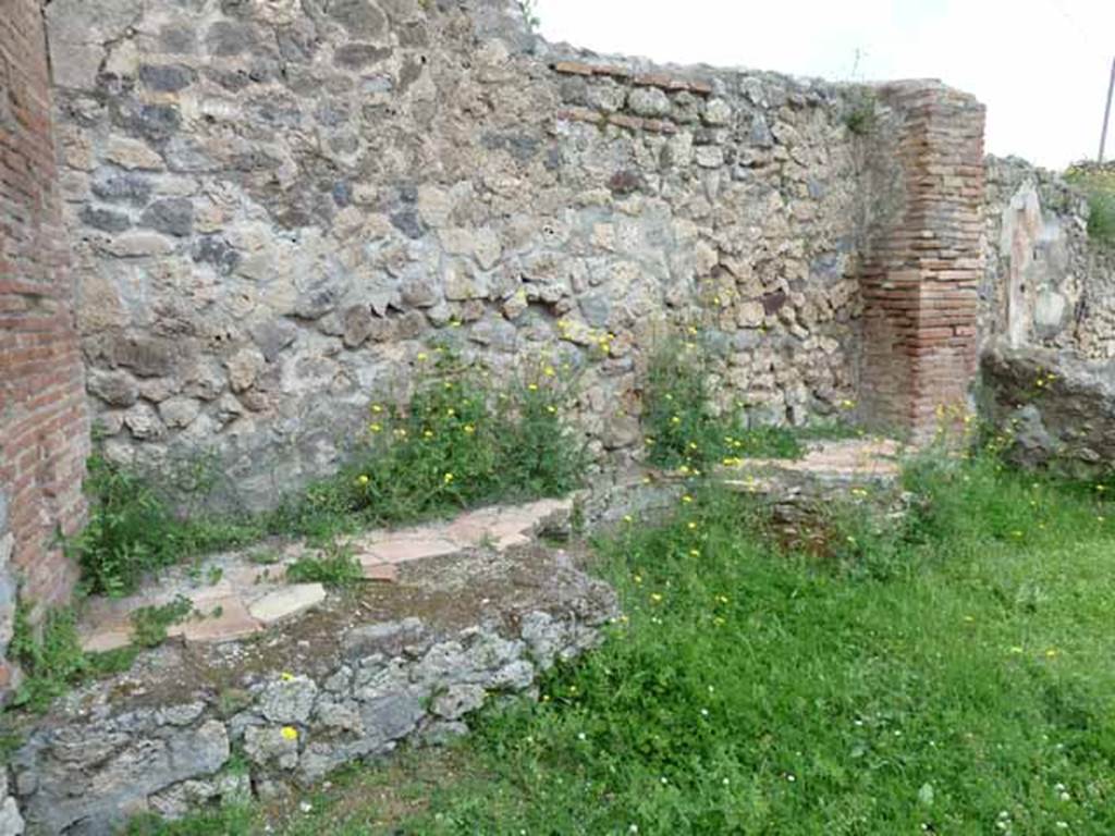 VII.2.27 Pompeii. May 2010. North wall with remains of podium, with large round space for large kettle or vat.