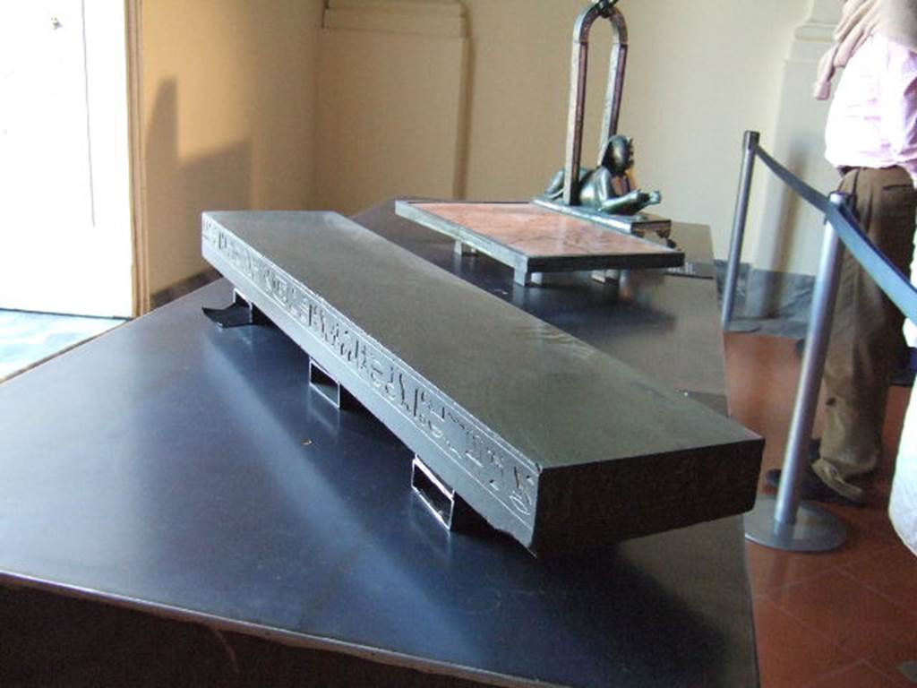 Basalt slab with a dedication from the Sacred banquet of Psammetico II, sovereign of twenty sixth dynasty of Egypt. It was reused as a threshold to the Triclinium. Fiorelli states that this was found in the Triclinium of VII.3.11 which is linked to VII.3.13. See Pappalardo, U., 2001. La Descrizione di Pompei per Giuseppe Fiorelli (1875). Napoli: Massa Editore. (p.86). Now in Naples Archaeological Museum where it is shown as being found in the Casa del Doppio Larario.