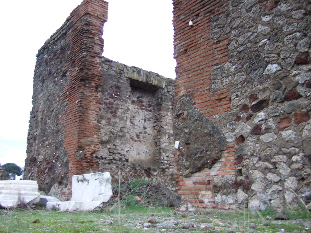 VII.4.1 Pompeii. December 2005. Looking north into the cella/sanctuary, from VII.4.2.
Originally the walls of the cella were lined with marble, these contained four recesses for statues on the sides.
