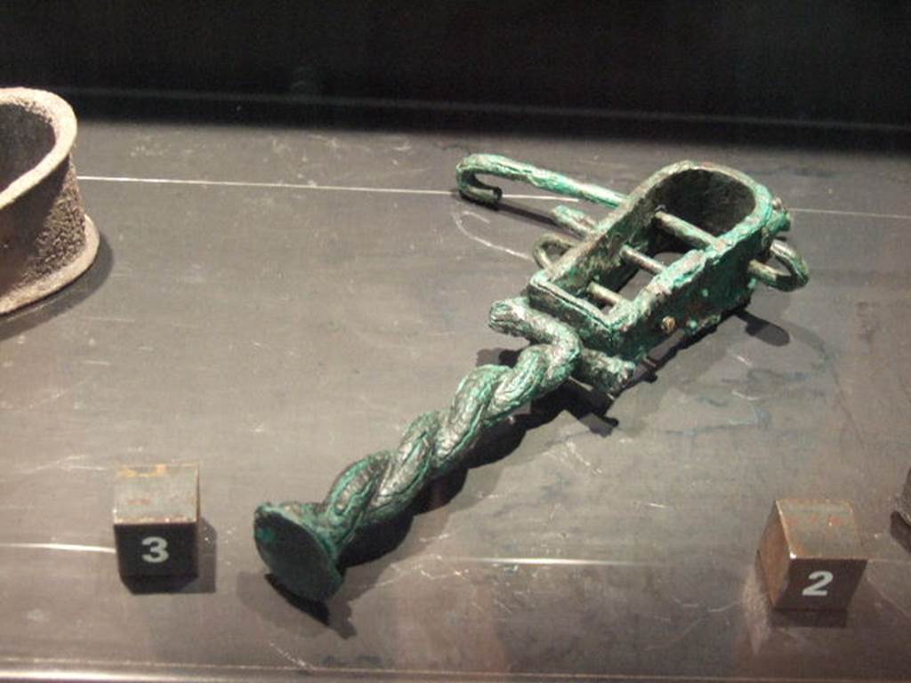 Bronze Sistrum found in VII.4.13.  Now in Naples Archaeological Museum.