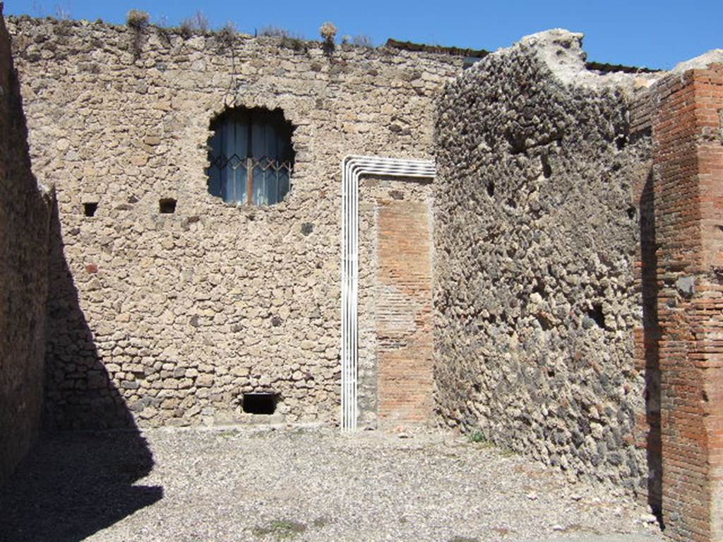 VII.4.20 Pompeii. September 2005. North and East wall.   At the rear of the north wall of this shop room would have been the dwelling.  The Lararium painting below, was found on the north wall of the kitchen of the dwelling. 
