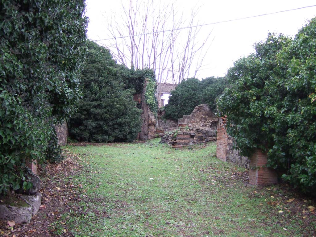 VII.4.26 Pompeii. December 2005. Looking north from shop to dwelling at rear.
On 13th September 1943, a bomb fell destroying the corridor from the shop and another two rooms nearby.
This caused the loss of wall plaster painted in the fourth style.
See Garcia y Garcia, L., 2006. Danni di guerra a Pompei. Rome: L’Erma di Bretschneider. (p.98)
According to Eschebach, the kitchen would have been at the rear of the dwelling.
See Eschebach, L., 1993. Gebäudeverzeichnis und Stadtplan der antiken Stadt Pompeji. Köln: Böhlau. (p.278)
