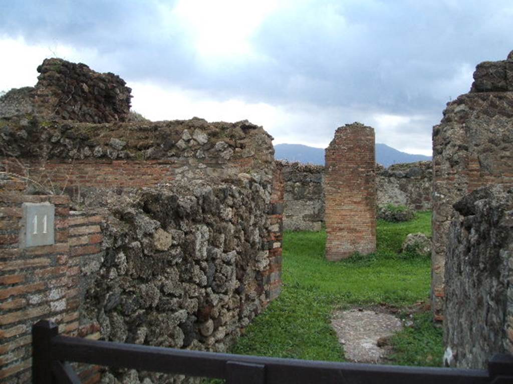 VII.6.11 Pompeii. December 2004. Looking south along entrance corridor towards site of atrium. This area was affected by the bombing in September 1943.  A photograph of the area can be seen showing the same brick pilaster, about the only thing left standing in the area. See Garcia y Garcia, L., 2006. Danni di guerra a Pompei. Rome: LErma di Bretschneider. (p.104, Fig 233 (Foto SAP neg. no.176)
