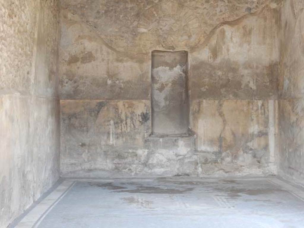 VII.7.5 Pompeii, May 2018. Triclinium (q), looking across flooring towards north wall with high niche. Photo courtesy of Buzz Ferebee.
According to Fiorelli –
“La sala da pranzo, o triclinio, ha due finestre, e due quadri.
Nel primo era rappresentato Triptolemo presso la biga dei serpenti, poggiato alla verga, che protende la mano a Proserpina per ricevere da lei le spighe del grano, mentre tiene accanto il canestro delle biade; 
nel secondo sembra espressa la discesa di Venere protettrice di Pompei sul lido, ove fu poi fabbricata la citta, con la dea che stringe il lungo scettro d’oro ed ha il peplo sulle gambe, e che seduta sulle spire del Tritone porge la mano ad Amore, per discendere sulla spiaggia, ove una giovane donna, personificazione del luogo, la riceve facendo libazione su di un’ara inghirlandata.”
(trans: "The dining-room, or triclinium, has two windows, and two paintings.
In the first was seen Triptolemus near to the serpent’s chariot, resting on the rod, extending his hand towards Proserpina to receive from her the ears of grain, while holding the basket of fodder nearby; 
In the second, it seemed to show the descent of Venus protector of Pompeii on the lido, where the city was built, with the goddess holding the long golden sceptre and having her legs covered, and sitting on the coils of the Triton holding her hand to Cupid, in order to descend to the beach, where a young woman, personification of the place, receives her by making a libation on the garlanded altar.”)
See Fiorelli, G. Guida di Pompei. 1877. (p.5).
