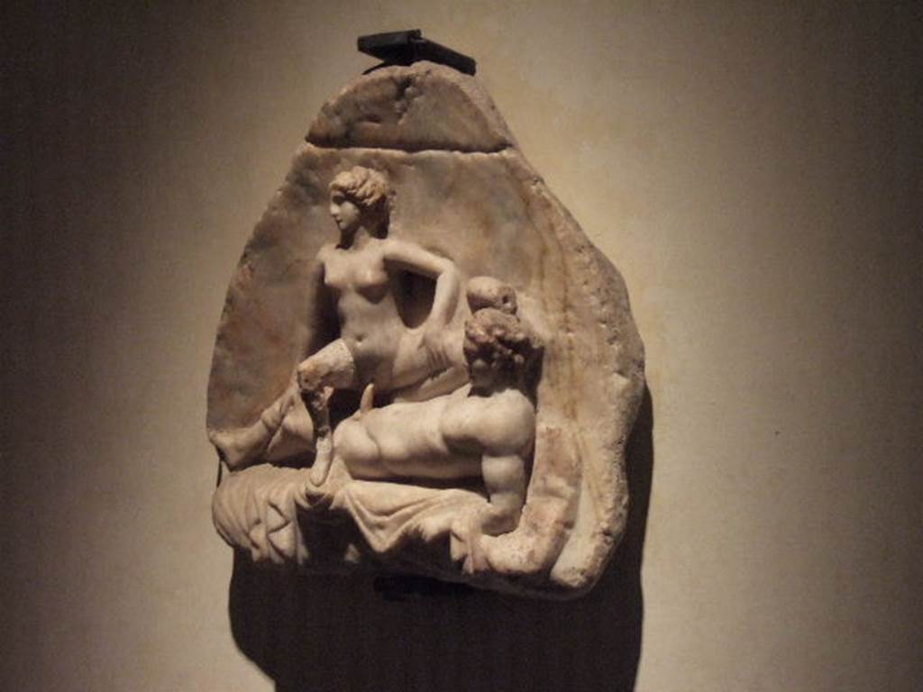 VII.7.18 Pompeii. Found 21st March 1859 inserted in a wall of the rear triclinium. Taberna Luci Numisi. 
“Un bassorilievo osceno in marmo”. See (PAH II, 683).
Now in Naples Archaeological Museum. Inventory number 27714.
See Pagano, M. and Prisciandaro, R., 2006. Studio sulle provenienze degli oggetti rinvenuti negli scavi borbonici del regno di Napoli. Naples : Nicola Longobardi, p .175.
See Fiorelli, G., 1875. Descrizione di Pompei. Napoli, p.248.
