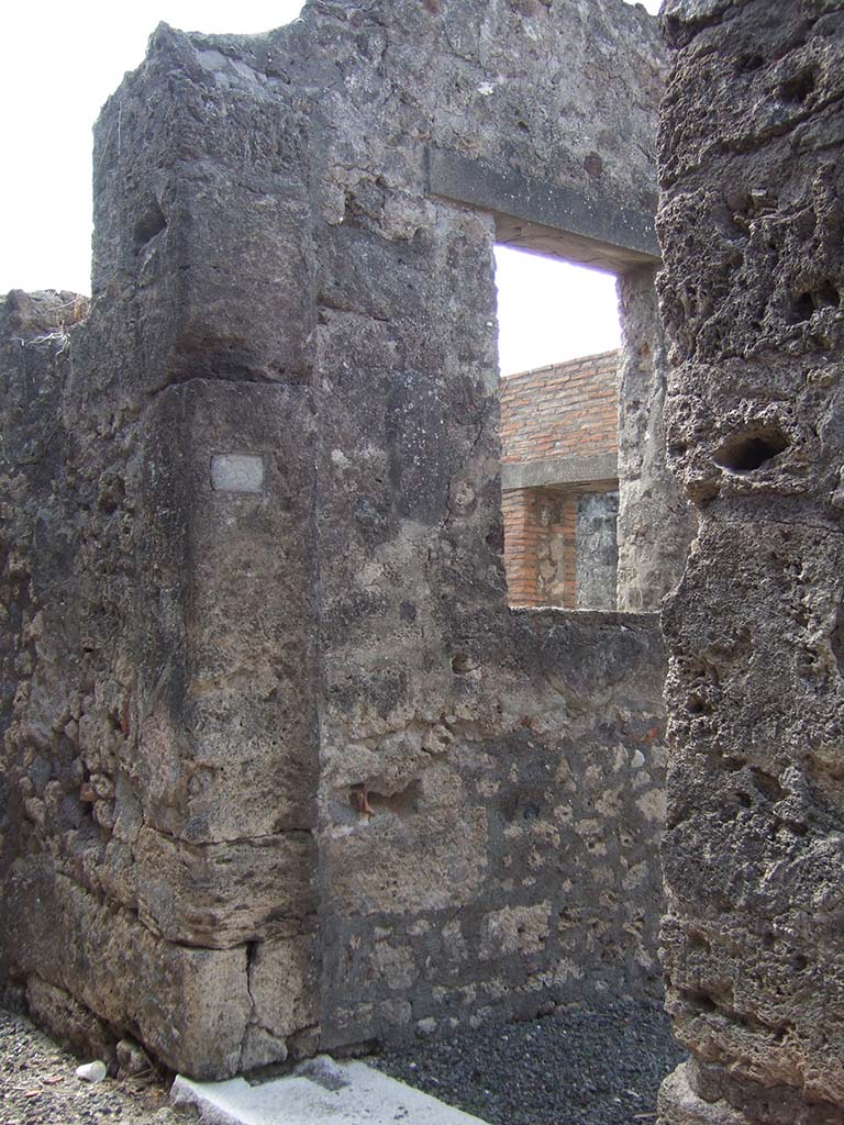 VII.7.23 Pompeii. September 2005. Entrance doorway.
According to Garcia y Garcia, this house was hit by a bomb on 13th September 1943.
It caused the ruin of three rooms on the east of the peristyle, and the south perimeter wall fell down.
See Garcia y Garcia, L., 2006. Danni di guerra a Pompei. Rome: L’Erma di Bretschneider. (p.116).
