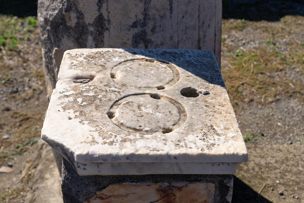 VII.7.32 Pompeii. October 2023. Detail of top of statue base in south-west corner. Photo courtesy of Johannes Eber.
