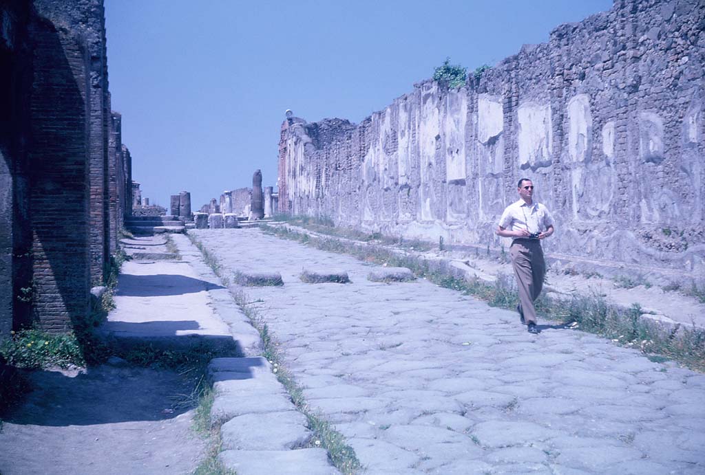 VII.9.1, Pompeii. June 1962. Via dell’Abbondanza, looking west along exterior south wall of Eumachia’s Building, (on right).
Photo courtesy of Rick Bauer.

