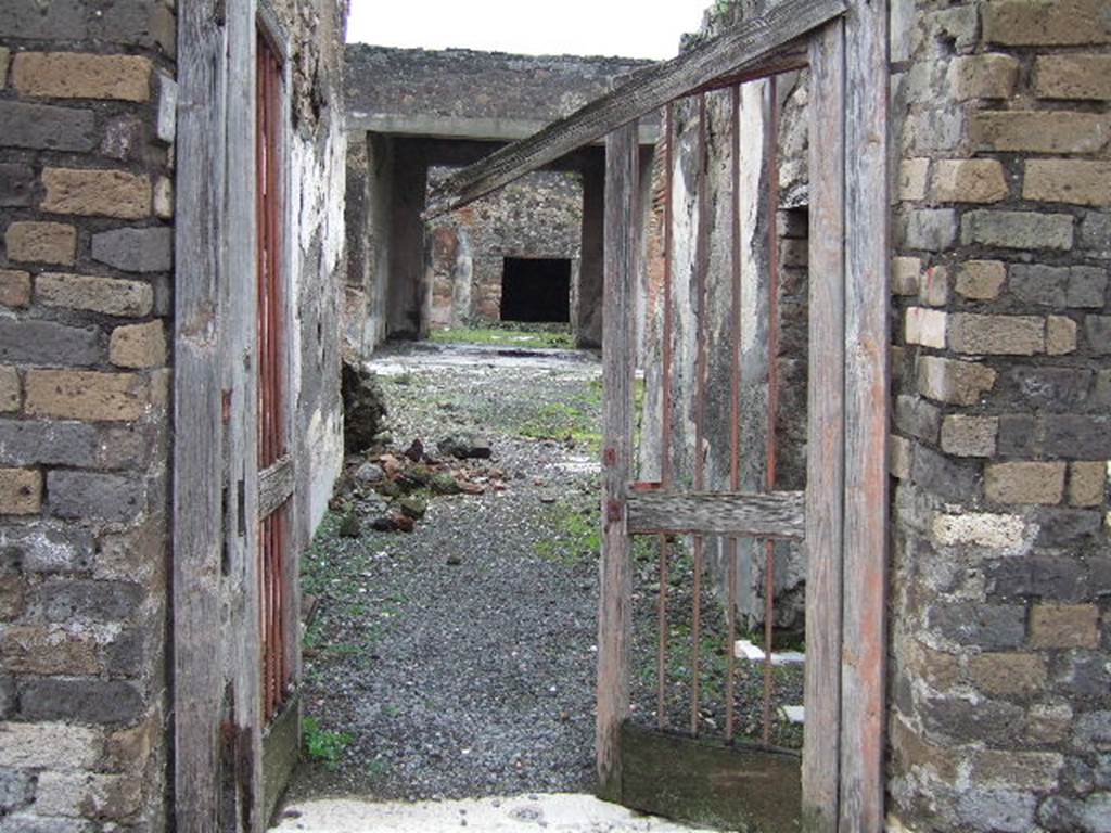 VII.10.3 Pompeii. December 2005. Looking east from entrance, through entrance fauces or corridor, 1. The doorway to the cella ostiaria (room 2) opened in the south-west (on the right). The entrance corridor was found with a floor of simple cocciopesto. The walls were covered with white plaster. 
