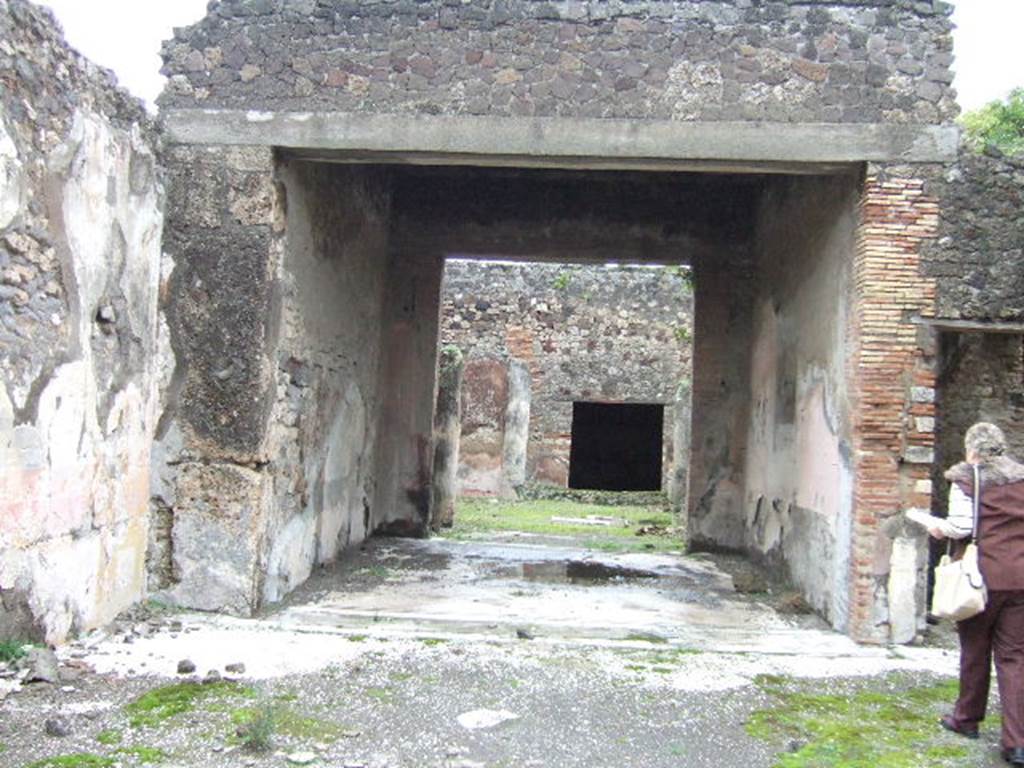 VII.10.3 Pompeii. December 2005. Room 7, looking east across tablinum, from atrium.
According to Breton, the tablinum was completely open onto the atrium and at the rear onto the peristyle. The floor was mosaic. The wall painting on the right (south) wall was preserved. In the red side panels of the south wall were paintings of two women holding masks. In the centre on a white panel was a painting of Bacchus finding sleeping Ariadne on the isle of Naxos. The painting from the left (north wall) no longer existed.
See Breton, Ernest. 1870. Pompeia, Guide de visite a Pompei, 3rd ed. Paris, Guerin.
See Helbig, W., 1868. Wandgemälde der vom Vesuv verschütteten Städte Campaniens. Leipzig: Breitkopf und Härtel. (874,881)
According to Amoroso, on the south wall the central panel had a blue background and in the side red panels were paintings of the muses, Melpomene (on the east end) and Thalia (on the west end). When redecorated the tablinum received a new mosaic floor, with a motif in the centre separated by a double black line of mosaics. At the atrium end (west end), the tablinum floor was separated from the atrium floor by a mosaic of twining ivy plants and leaves enclosed by black lines on the white background.(see fig 35b, on p.107) (p.75) 
Studi della Soprintendenza archeologica di Pompei, 22: l”Insula VII, 10 di Pompei, by Angelo Amoroso, (p.75, figs 16,1 and 16,2)
