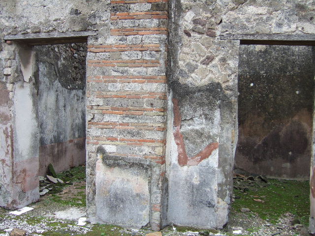 VII.10.3 Pompeii. December 2005. Doorways to rooms 10 and 11, cubiculi on south side of atrium. Both of these rooms also had flooring of red cocciopesto. The doorway, on the left, had a threshold formed by two rectangular limestone slabs, marked in the centre with a circular recess for the closing fixing for the double-set of doors. 
Studi della Soprintendenza archeologica di Pompei, 22: l”Insula VII, 10 di Pompei , by Angelo Amoroso. (p.55) 
