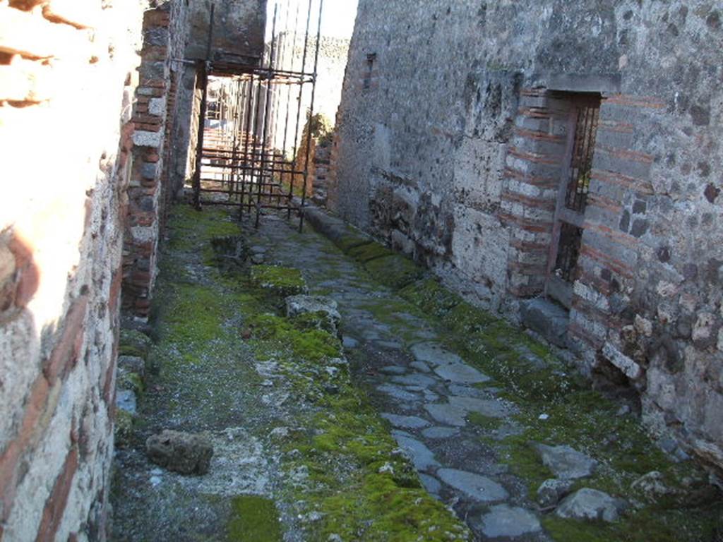 VII.12 Pompeii, on left. December 2005. Vicolo del Balcone Pensile, looking east . VII.10.8 on right.

