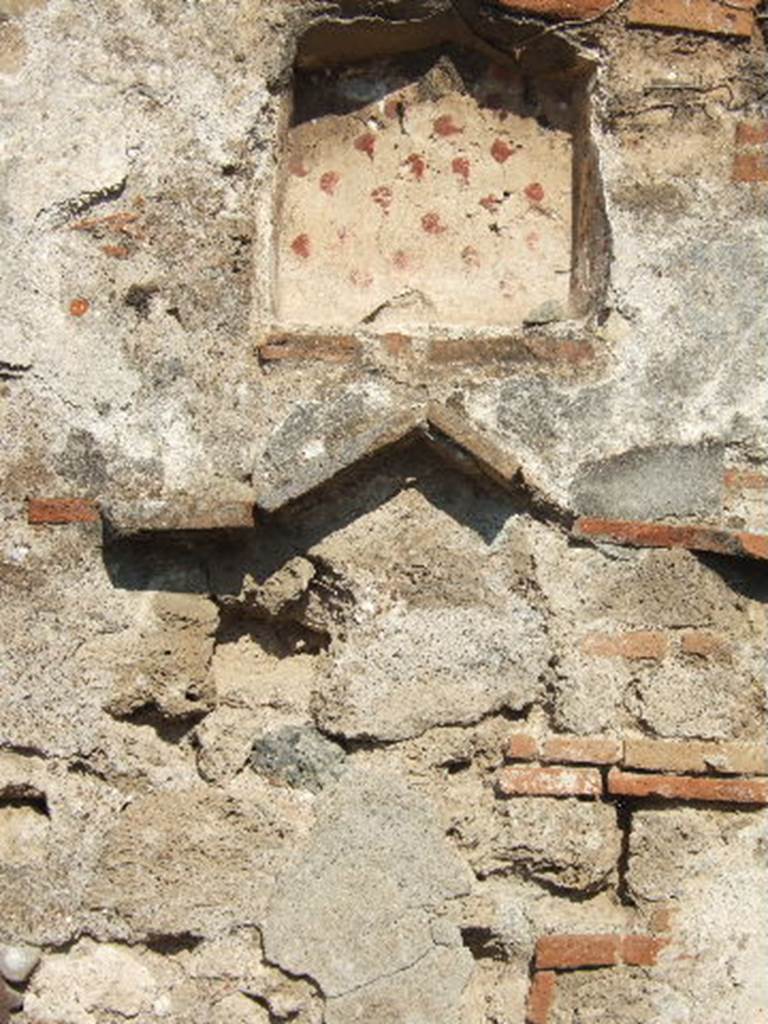 VII.12.13 Pompeii. September 2005. Niche on east wall near oven.
According to Boyce, on the wall of the room with the oven, near the hearth, was a lararium painting. Into the panel, near the top, was set a rectangular niche with projecting floor. The inside walls were coated with white stucco decorated with spots of many colours. On the wall on each side of it were the traces of the figure of a Lar. Below the niche a pediment was formed by bricks embedded in the wall. Within the pediment were painted a cock and a peacock, one above the other.
On the wall below the pediment were painted two serpents confronted at an altar. At the side of the altar stood Vesta, wearing a wreath of flowers. At her side stood an ass, its head appearing above the altar.
See Boyce G. K., 1937. Corpus of the Lararia of Pompeii. Rome: MAAR 14. (p.71, no.318)