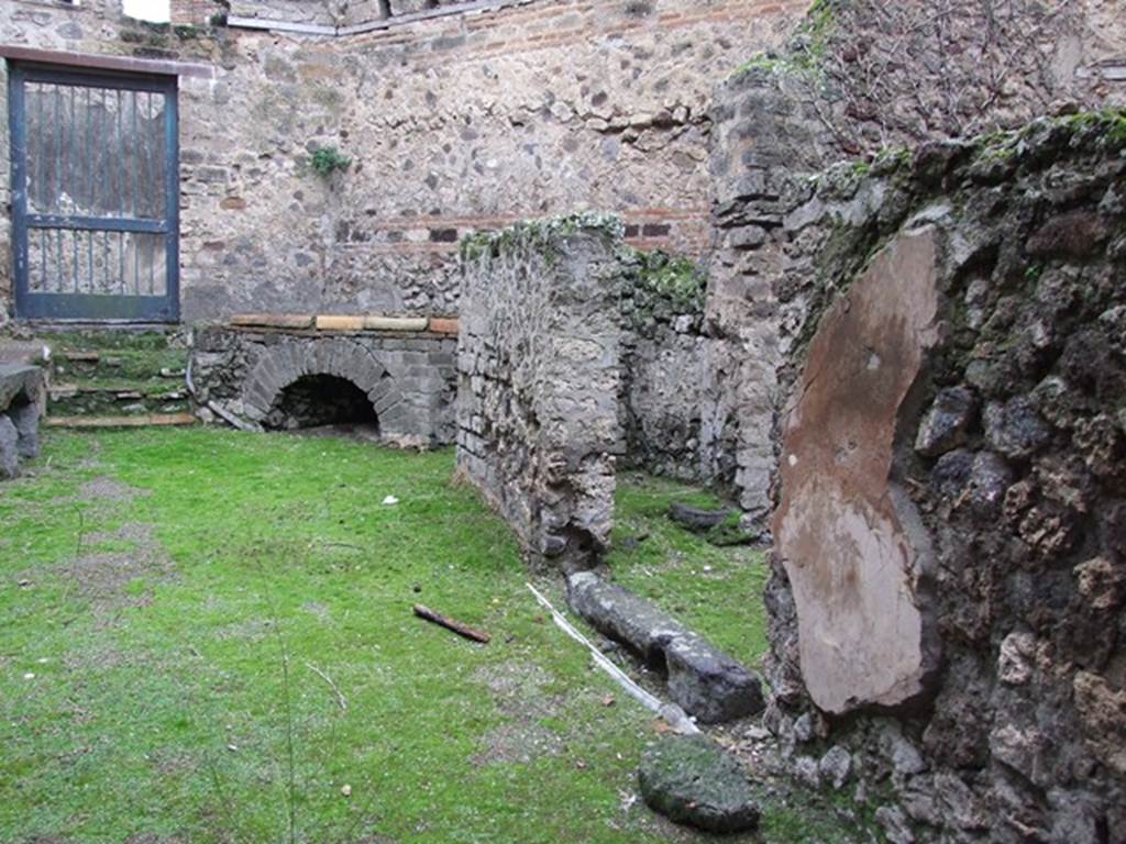 VII.12.17 Pompeii. December 2006. Looking from entrance doorway towards doorway into VII.12.21. A brick and tile hearth with wood store underneath is on the right of the doorway.

