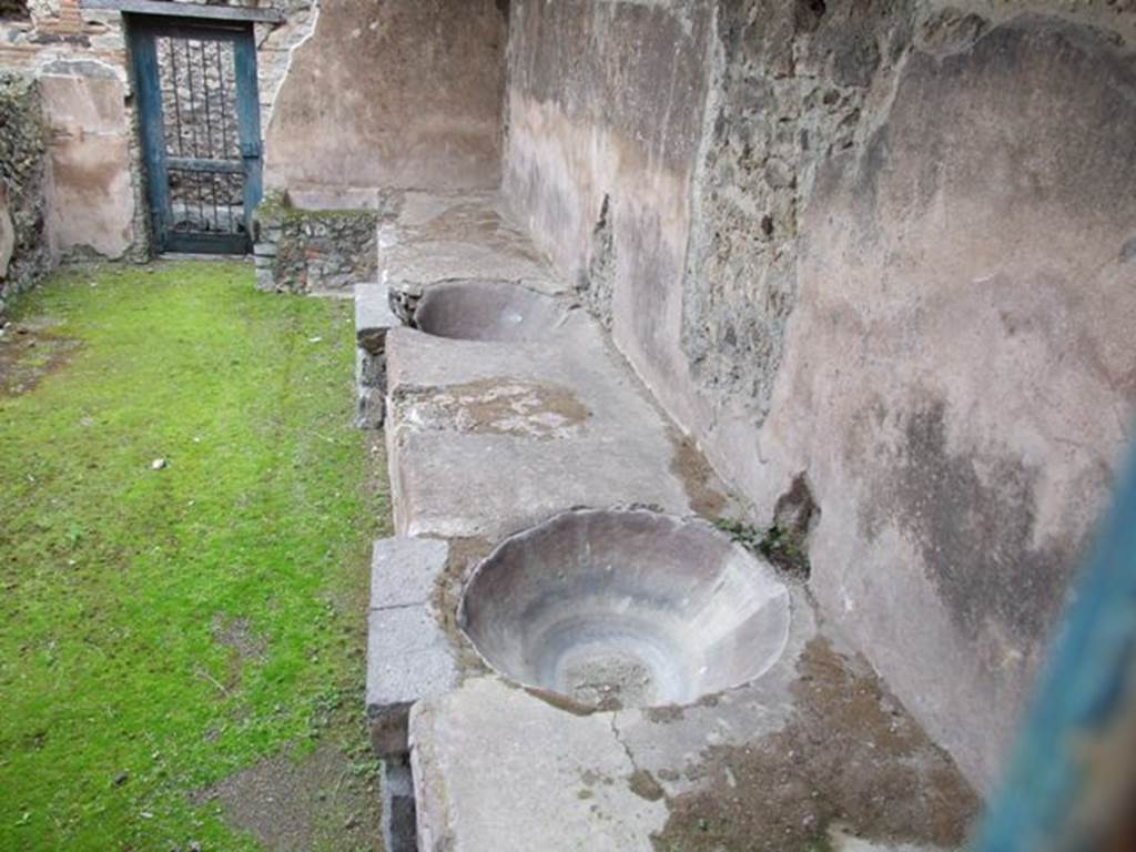 VII.12.17 Pompeii. March 2009. Looking east across south side, towards two round water basins set in podium, from VII.12.21. 
