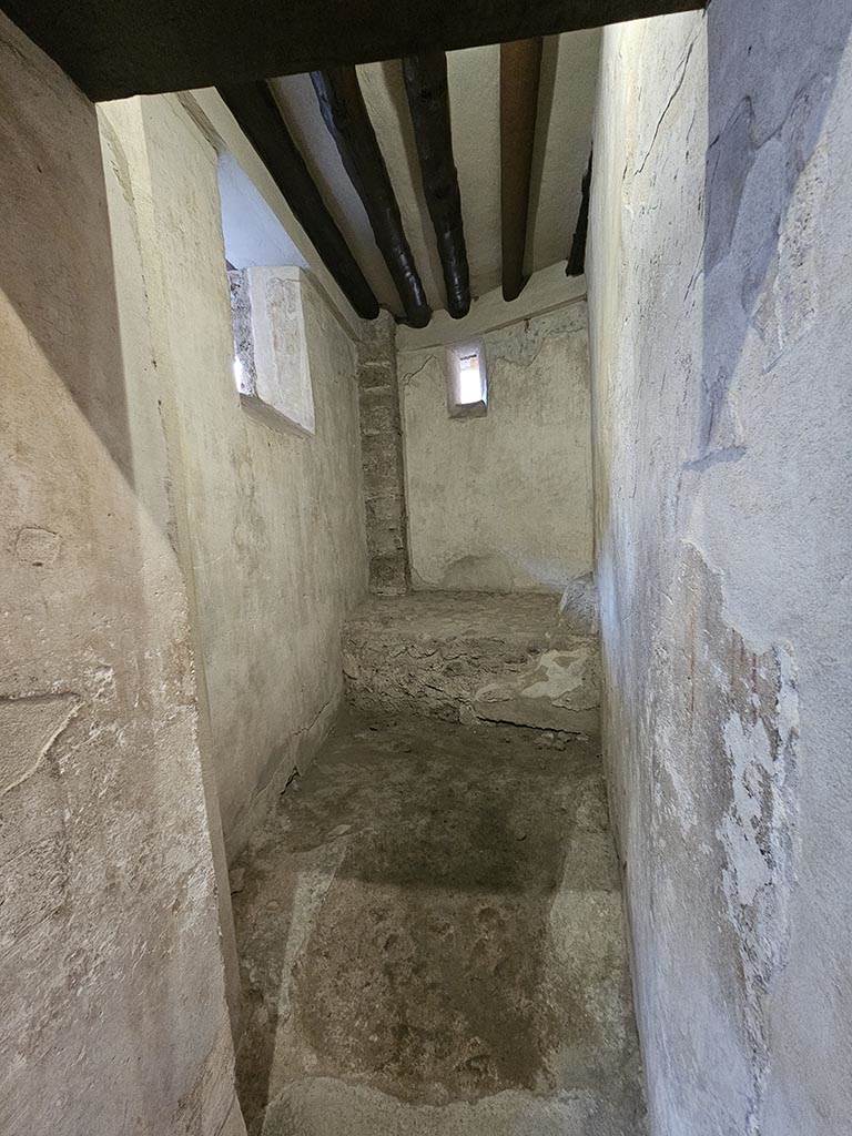 VII.12.18 Pompeii. November 2024.
Looking south through doorway into room for use by prostitute, on south side at east end.
Photo courtesy of Annette Haug.
