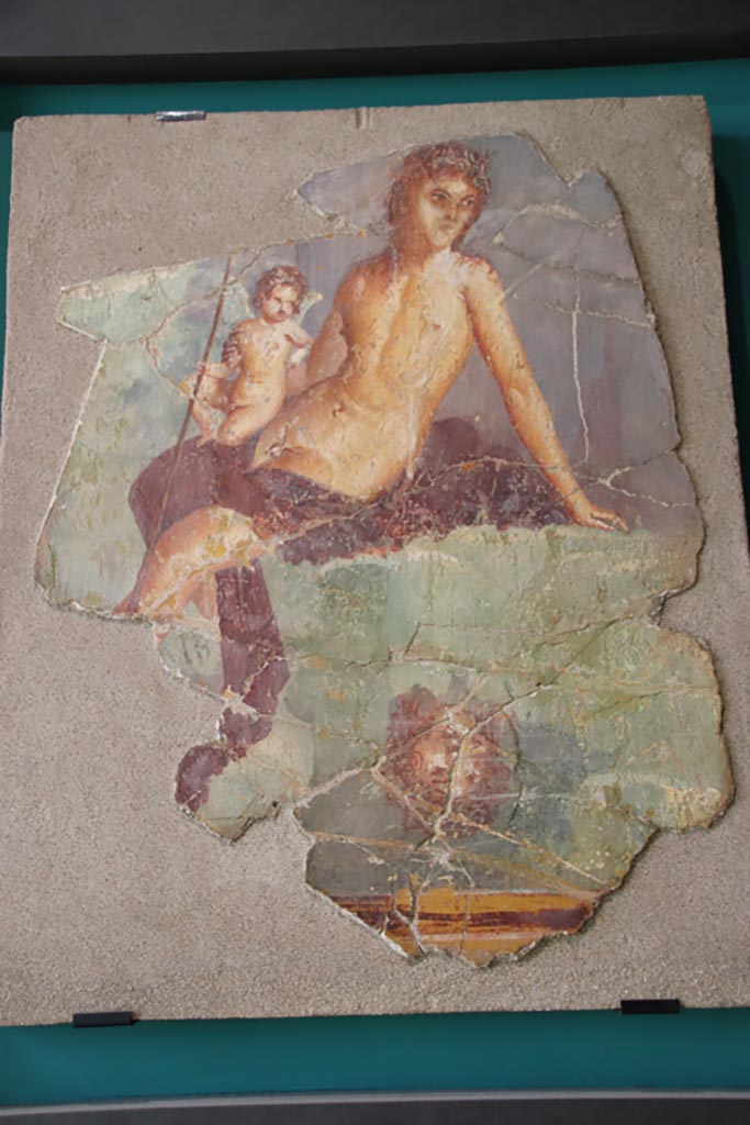 VII.15.2 Pompeii. October 2022. 
Painting of Narcissus and Eros from the tablinum, found in pieces and restored. 
Photo courtesy of Klaus Heese, photographed at an exhibition in the Palaestra.
