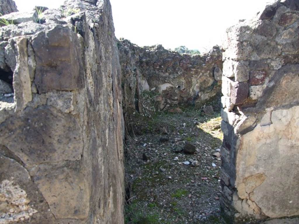 VII.15.2 Pompeii. March 2009. Tepidarium with doorway into caldarium.
The caldarium had a hypocaust system, complete with suspensurae beneath its floor. Regulae mammatae lined its south, west, and north walls. The praefurnium was stoked from the kitchen, which was on the west side.  The wall decoration of the caldarium was Second style, but no further details were recorded.  The floor was paved with cocciopesto.
See Franklin, J.L., 1990. Pompeii, the Casa del Marinaio and its history. Rome: LErma di Bretschneider

