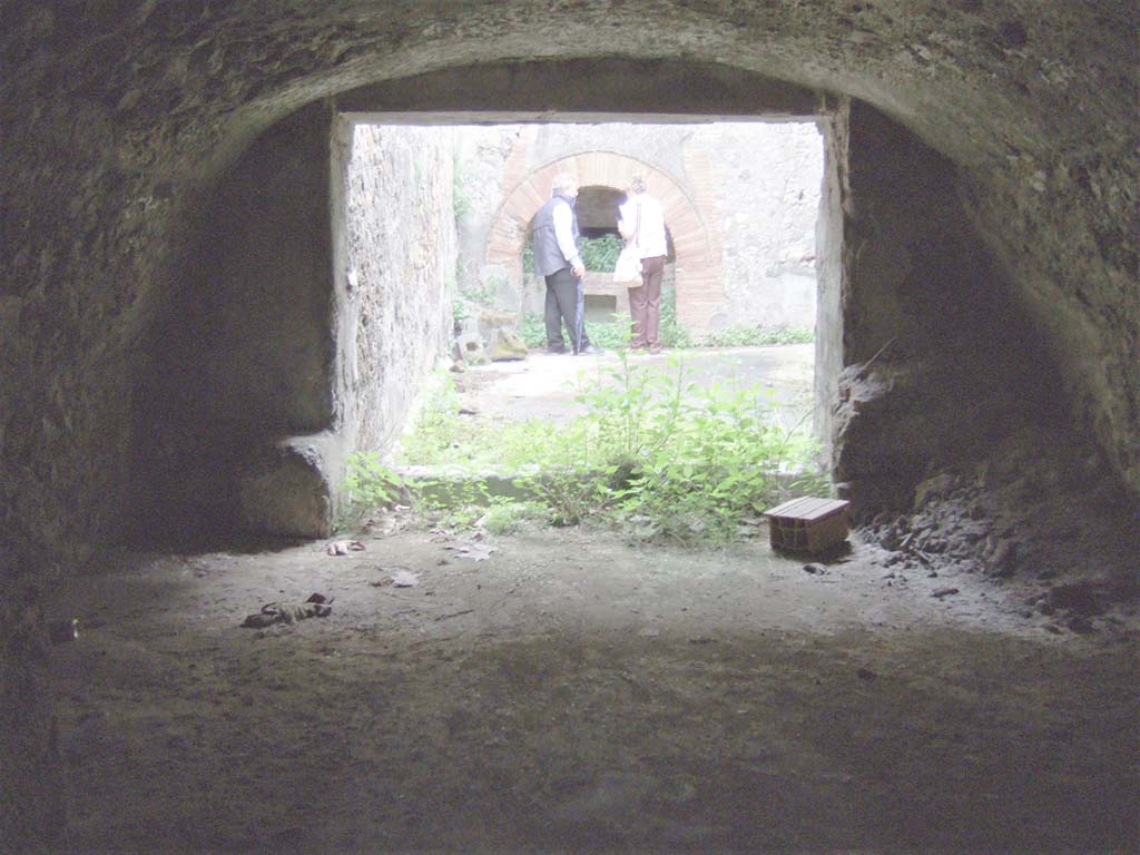 VII.15.16 Pompeii. May 2006. Looking across room (L) towards unroofed courtyard of bakery.
The small doorway through to storerooms T, V, W, X, Y and Z, is in the south wall of room L, on the right.