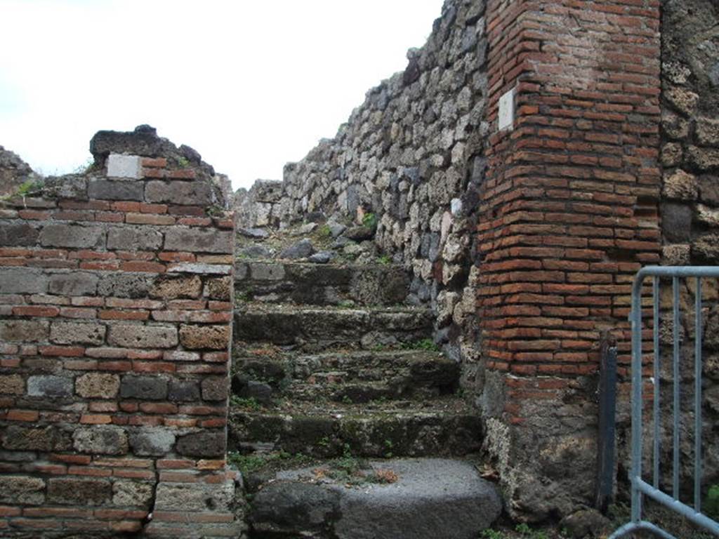VII.16.5 Pompeii. December 2004. Steps to upper floor, looking north.
Originally, under these stairs would have been a small storeroom or cupboard with a doorway in the west wall of VII.16.6.
See Eschebach, L., 1993. Gebudeverzeichnis und Stadtplan der antiken Stadt Pompeji. Kln: Bhlau. (p.347)
 