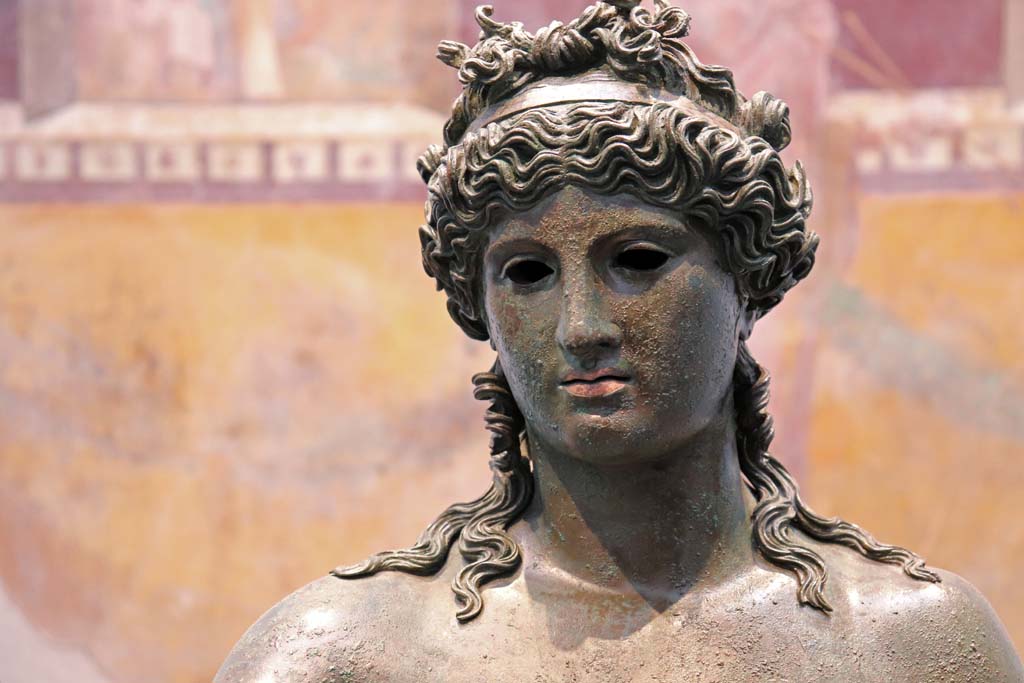 VII.16.17-22 Pompeii. February 2021.
Detail of head of bronze Ephebus, used as an oil lamp holder, found in dining room.
Photographed on display in Antiquarium. Photo courtesy of Fabien Bièvre-Perrin (CC BY-NC-SA).