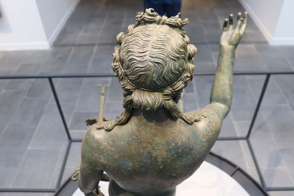 VII.16.17-22 Pompeii. February 2021.
Rear of statue of the bronze Ephebus, used as an oil lamp holder, found in dining room.
Photographed on display in Antiquarium. Photo courtesy of Fabien Bièvre-Perrin (CC BY-NC-SA).