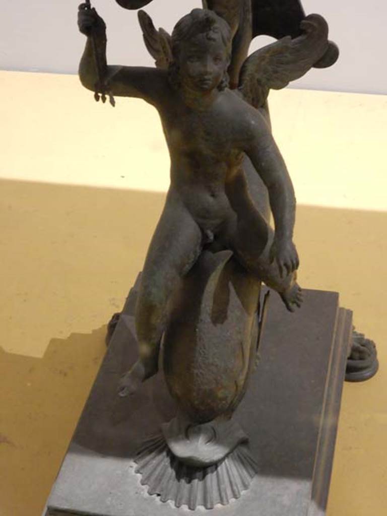 VII.16.17-22, Pompeii. May 2018. Bronze and marble table.
Base with bronze cupid riding a dolphin, Archaeological Park of Pompeii, inv. 13371.  
Photo courtesy of Buzz Ferebee.
