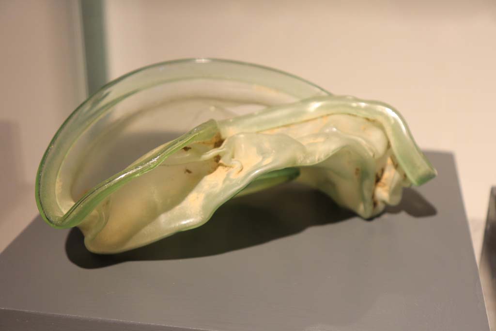 VIII.1.4 Pompeii. February 2021 Glass ointment bowl distorted by the eruption, from I.7.11/18.
Photo courtesy of Fabien Bièvre-Perrin (CC BY-NC-SA).
