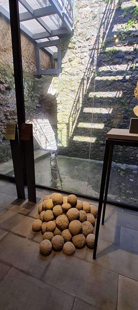 VIII.1.4 Pompeii. April 2022. 
Lava projectiles from catapults. Photo courtesy of Giuseppe Ciaramella.
According to the information card –
“Balls from catapults have been found in many houses, especially in the north-west sector of the town, where the fighting was more intense and where most of the defenders were gathered.”
(Proiettili di catapulta.
Palle di catapulta sono state rinvenute in numerose case, soprattutto nel settore nord-occidentale della citta, dove piu intensi furono gli scontri e dove fu radunato il maggior numero di difensori.)
