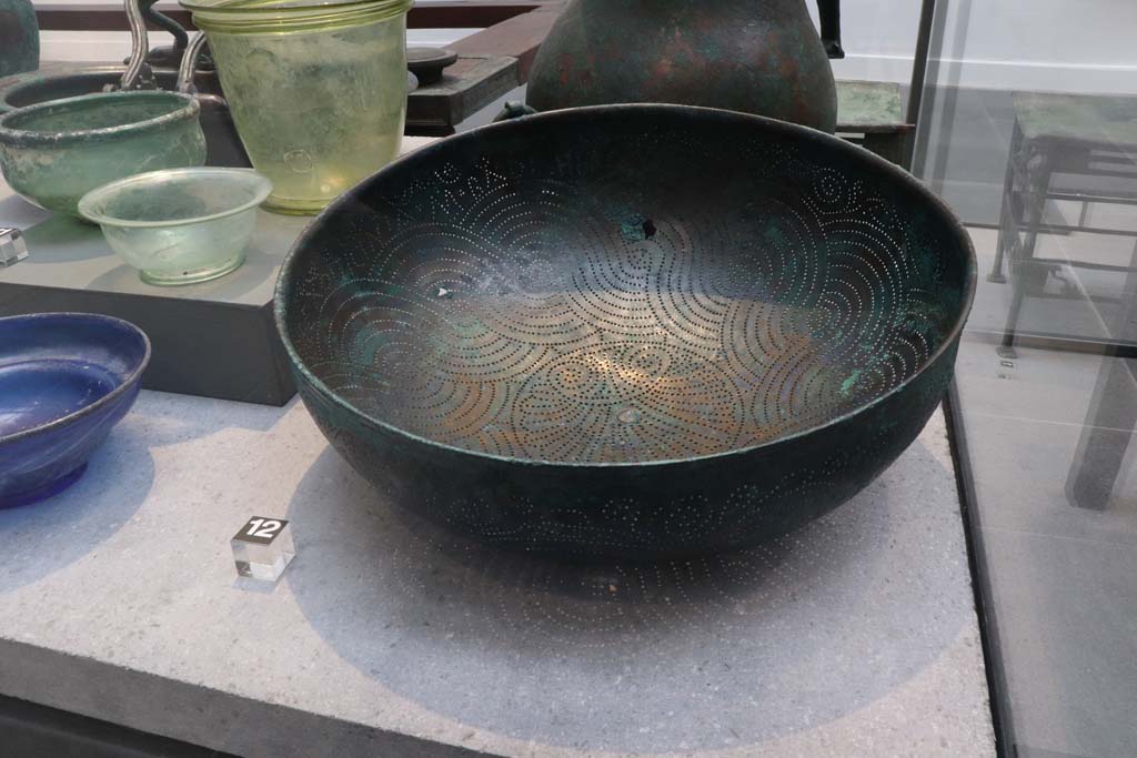 VIII.1.4 Pompeii. February 2021.
Bronze strainer with inscription, on the left are glass bowls and beakers, all found in House of Menander at I.10.4.
Photo courtesy of Fabien Bièvre-Perrin (CC BY-NC-SA).
