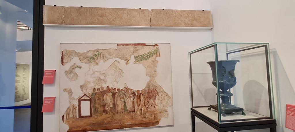 VIII.1.4 Pompeii. April 2022.
Painting on wall from IX.7.1 showing procession in honour of the goddess Cybele. Photo courtesy of Giuseppe Ciaramella.
Her cult statue is seated on a wooden litter beside which stand four bearers with garlands in their hair.
Behind her are two rows of worshippers led by a priest and priestess.
Some of the worshippers are playing the Pan Pipes or double flute, others beating tambourines or clashing cymbals.
See Fröhlich, T., 1991, Lararien und Fassadenbilder in den Vesuvstädten. Mainz: von Zabern. (F63: p.332, T. 59,2).