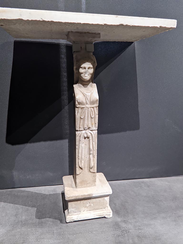 VIII.1.4 Pompeii. April 2022.
Foot/leg of a table, on display in exhibition in the Palaestra. Photo courtesy of Giuseppe Ciaramella.
Could this be one of the monopodiums for supporting a table, as mentioned by Fiorelli, in either -
Fiorelli, G., 1897. Guida di Pompei, (p.110).
Fiorelli, G., 1877. Guida di Pompei. (p.108).
(for details of these pages, see VIII.1.4, part 5).