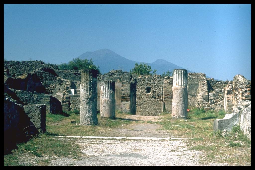 VIII.2.28 Pompeii. Looking north across tablinum across atrium towards entrance.
Photographed 1970-79 by Günther Einhorn, picture courtesy of his son Ralf Einhorn.
According to Richardson, the tablinum was open on both its north and south sides.
On the atrium end, the sill preserved cuttings for some sort of closure, perhaps a folding screen.
In both its west and east wall, it had doorways at its south end, the west doorway leading to a large exedra, which was also open across its whole south side to the view.
On the east side of the tablinum was a corridor, the doorway in the east wall led into this corridor.
From the corridor was a doorway to a small cubiculum, and a small exedra also facing south across the terrace.
Beyond these rooms stretched a broad flat terrace that must have been finished with a parapet, no trace of which survives.
See Richardson, L., 1988. Pompeii: An Architectural History. Baltimore: John Hopkins University Press. (p.231-2).
