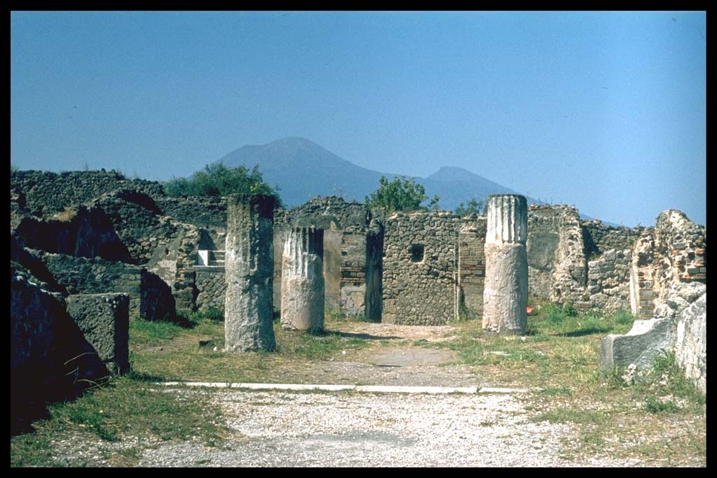 VIII.2.28 Pompeii. Looking north across tablinum across atrium towards entrance.
Photographed 1970-79 by Günther Einhorn, picture courtesy of his son Ralf Einhorn.
According to Richardson, the tablinum was open on both its north and south sides.
On the atrium end, the sill preserved cuttings for some sort of closure, perhaps a folding screen.
In both its west and east wall, it had doorways at its south end, the west doorway leading to a large exedra, which was also open across its whole south side to the view.
On the east side of the tablinum was a corridor, the doorway in the east wall led into this corridor.
From the corridor was a doorway to a small cubiculum, and a small exedra also facing south across the terrace.
Beyond these rooms stretched a broad flat terrace that must have been finished with a parapet, no trace of which survives.
See Richardson, L., 1988. Pompeii: An Architectural History. Baltimore: John Hopkins University Press. (p.231-2).
