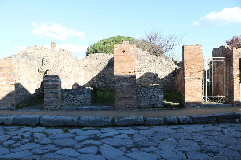 VIII.3.24 Pompeii, on left, VIII.3.23, VIII.3.22, and VIII.3.21, on right. December 2018.  
Looking east to entrance doorways from Via delle Scuole. Photo courtesy of Aude Durand.


