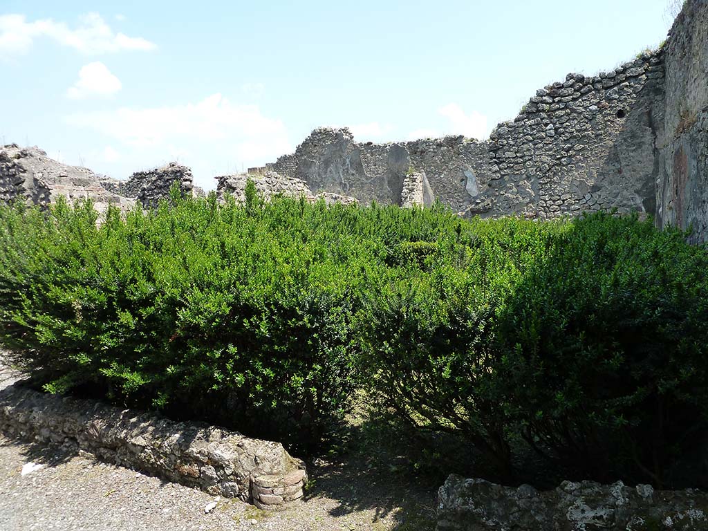 VIII.5.24 Pompeii. May 2010. Looking east across peristyle from south-west corner.
According to PPM –
In the south-east corner of the peristyle, between the columns was a low small wall which, around its inside, was decorated with a series of painted panels in IV Style: some of those representing Nilotic scenes have been cut and taken to Naples Museum, while those that showed, for example, a lion chasing a deer or roe deer... a marsh plant... a rooster... an ibis pecking at a toad (see Mau) remained in situ and have been destroyed by time. These were on a red background.
See Carratelli, G. P., 1990-2003. Pompei: Pitture e Mosaici, VIII. Roma: Istituto della enciclopedia italiana, (p. 605).
