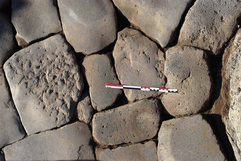 Fig. 24 – Pompéi, boulangerie VIII 6, 1.9-11 – Intersection du dallage des trois meules situées au sud-ouest de la salle.
Un des blocs ne présente aucune usure mais seulement les traces de façonnage au pic, signe qu’il n’a pas été piétiné par le passage des équidés.
Cliché : N. Monteix /EFR.