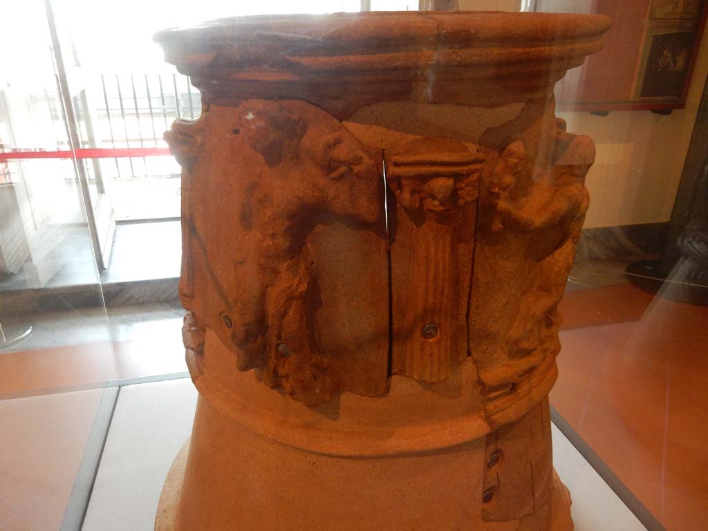 VIII.7.28 Pompeii. June 2019. Terracotta decorated puteal, on the left is a youth with a jar on his shoulder and on the right is Hercules with club.
Photo courtesy of Buzz Ferebee.
