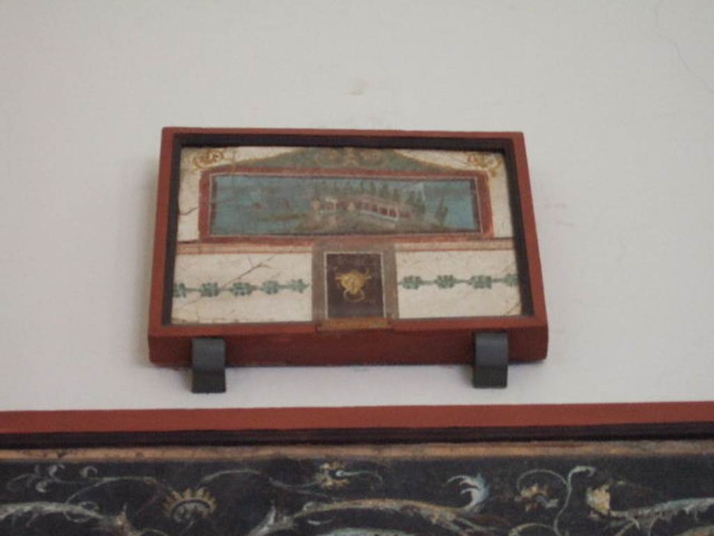 VIII.7.28 Pompeii. South part of east wall of portico. Picture with landscape, surmounted by a pediment and with a small panel underneath with a bovine head. 
Now in Naples Archaeological Museum. Inventory number 9444.

