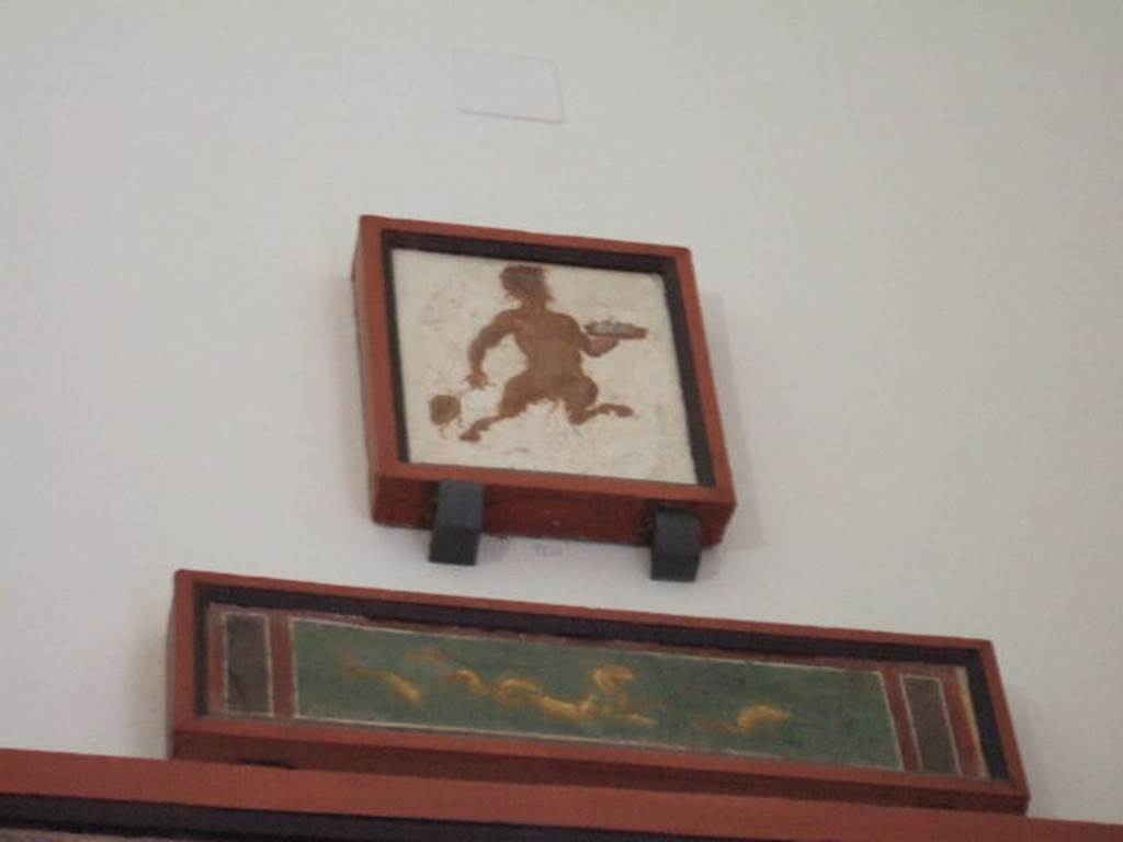 VIII.7.28 Pompeii. 2010. Two paintings from the south end of the east portico. 
Upper painting is of Pan with a drum and a plate for offerings.
Now in Naples Archaeological Museum. Inventory number 9128.
Lower painting is of a marine lion with dolphins.
Now in Naples Archaeological Museum. Inventory number 8884.
