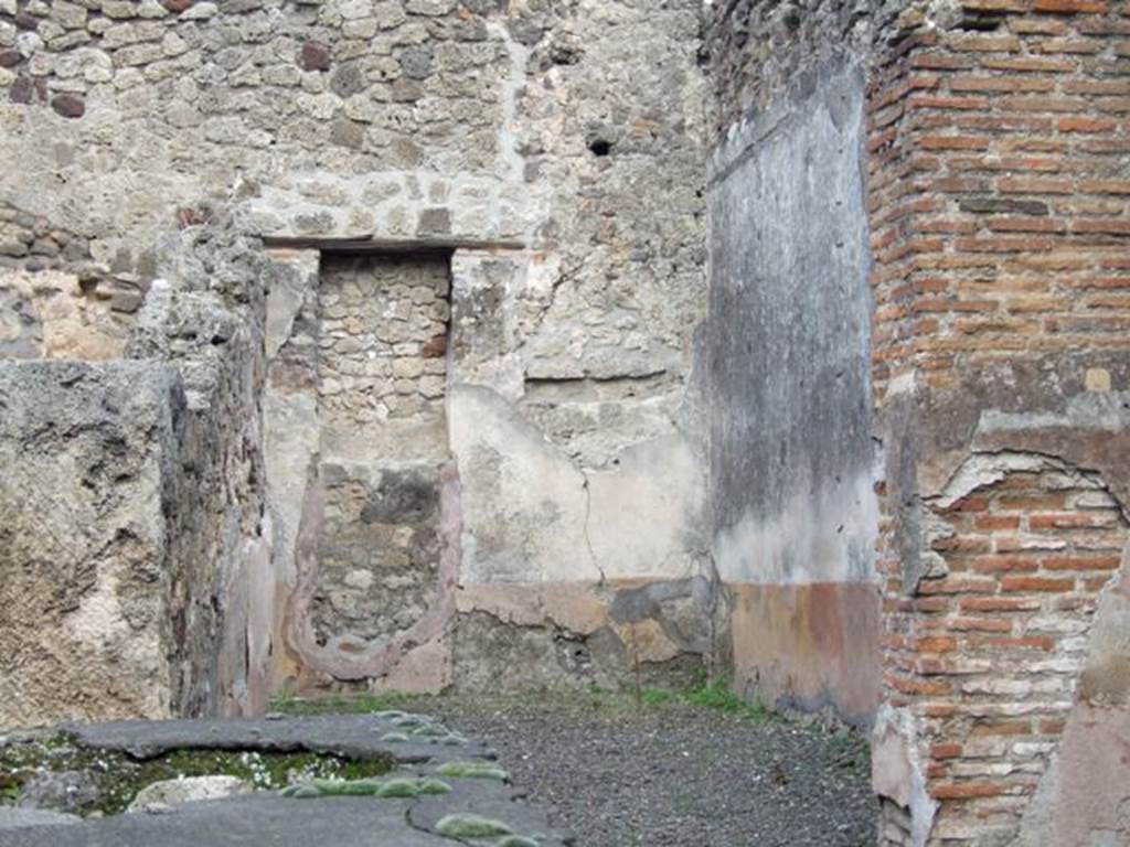 IX.1.8 Pompeii. December 2007. Rear room for the clients, in south-east corner. This room would have been decorated with a yellow zoccolo/plinth subdivided into panels, the middle zone would have been painted white. On the east side of the south wall, with a yellow zoccolo/plinth, a vertical red stripe was visible dividing panels on the white middle zone of the wall.