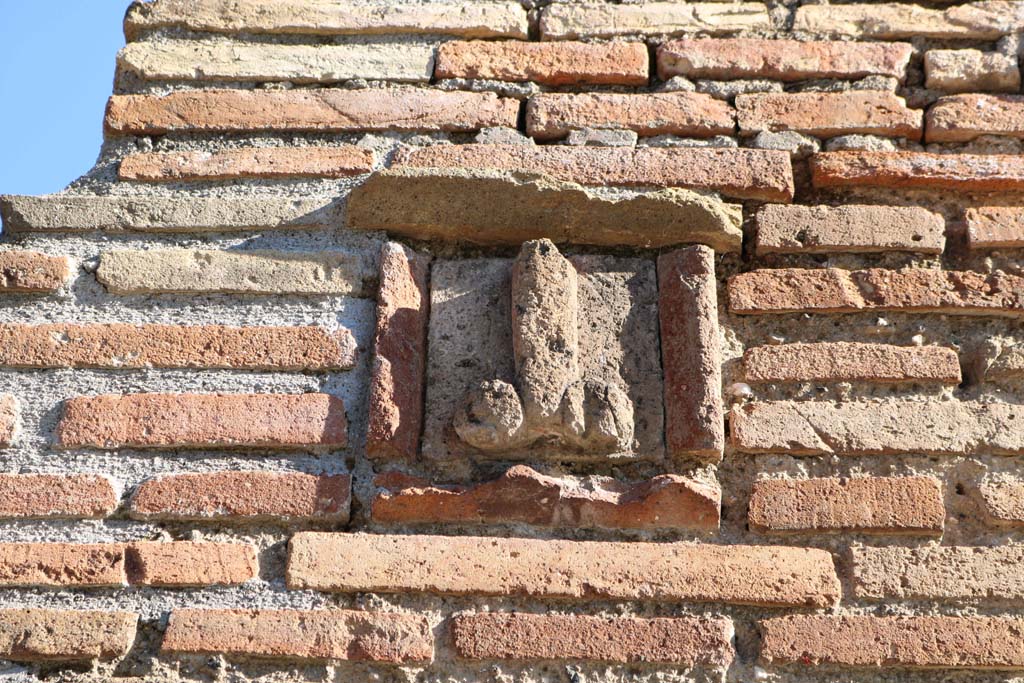 IX.1.13, and IX.1.14, Pompeii. December 2018.
Detail of tufa phallus set into pilaster between entrances. Photo courtesy of Aude Durand.