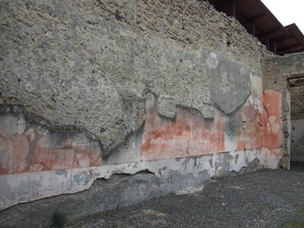 IX.1.22 Pompeii. December 2007.Room 1, west wall of atrium.  According to Bragantini, the dado of the atrium walls was painted but faded and uncoloured. The middle zone was red, and on the west wall was a large central panel. The side panels had paintings in them, and on the north side was a medallion. On the west side of the door in the north wall, would have been another painted medallion of a landscape.
See Bragantini, de Vos, Badoni, 1986. Pitture e Pavimenti di Pompei, Parte 3. Rome: ICCD. (p.399, atrio ‘b’)
