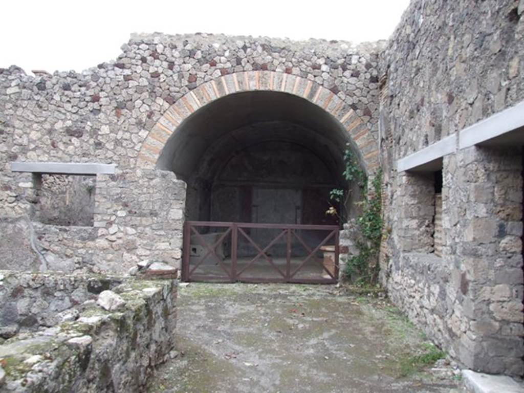 IX.2.10 Pompeii. December 2007. Looking east along the walkway on the south side of the peristyle, towards the vaulted room or tablinum. On the right is the window and doorway of a cubiculum, with red zoccolo and panelled middle zone to the walls, but now all faded.
On the left is the window of a triclinium, described by Fiorelli as an oecus.
See Fiorelli, G, (1875), Descrizione di Pompei, (p.380)