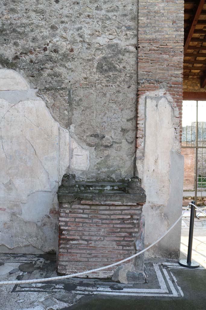 IX.3.5 Pompeii. December 2018.
Room 3, looking west to remains of aedicula altar in south-west side of atrium. Photo courtesy of Aude Durand.
According to Boyce –
The aedicula, of which now only remains the rectangular podium (1.20 by 0.83, h.1.10) and the bases of the two columns which supported the roof over the shrine. The podium is coated with stucco and painted in imitation of marble and in the centre of each side is a painted wreath.
The whole structure was richly ornamented with mouldings of coloured stucco.
See Boyce G. K., 1937. Corpus of the Lararia of Pompeii. Rome: MAAR 14. (p.83, no.408).
See Giacobello, F., 2008. Larari Pompeiani: Iconografia e culto dei Lari in ambito domestico. Milano: LED Edizioni, (p.249, no.A38)